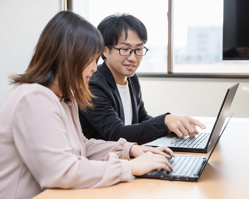 先輩が後輩に仕事を教えている様子