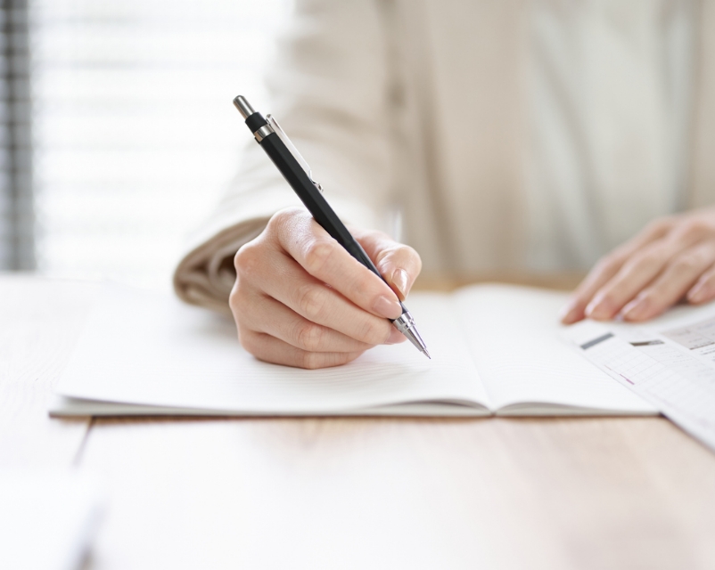 ペンを持ち勉強している女性